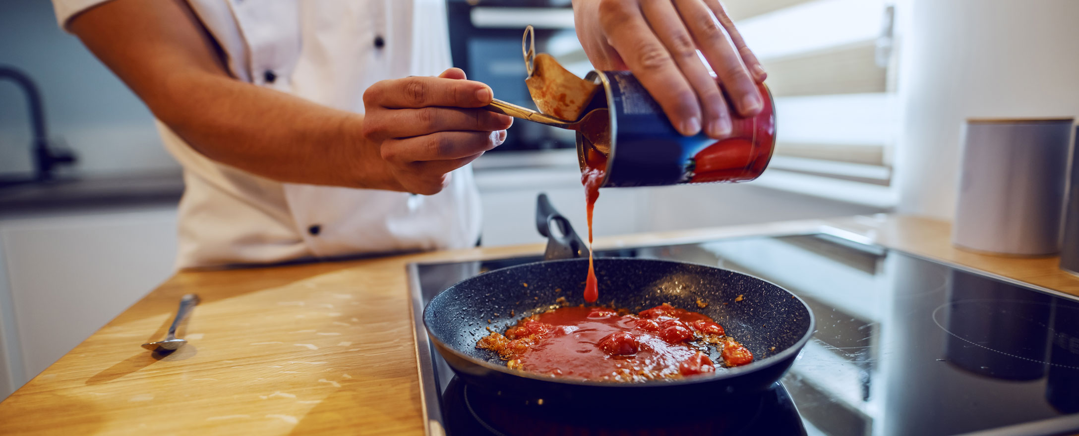 mann kocht mit tomatensauce aus dose