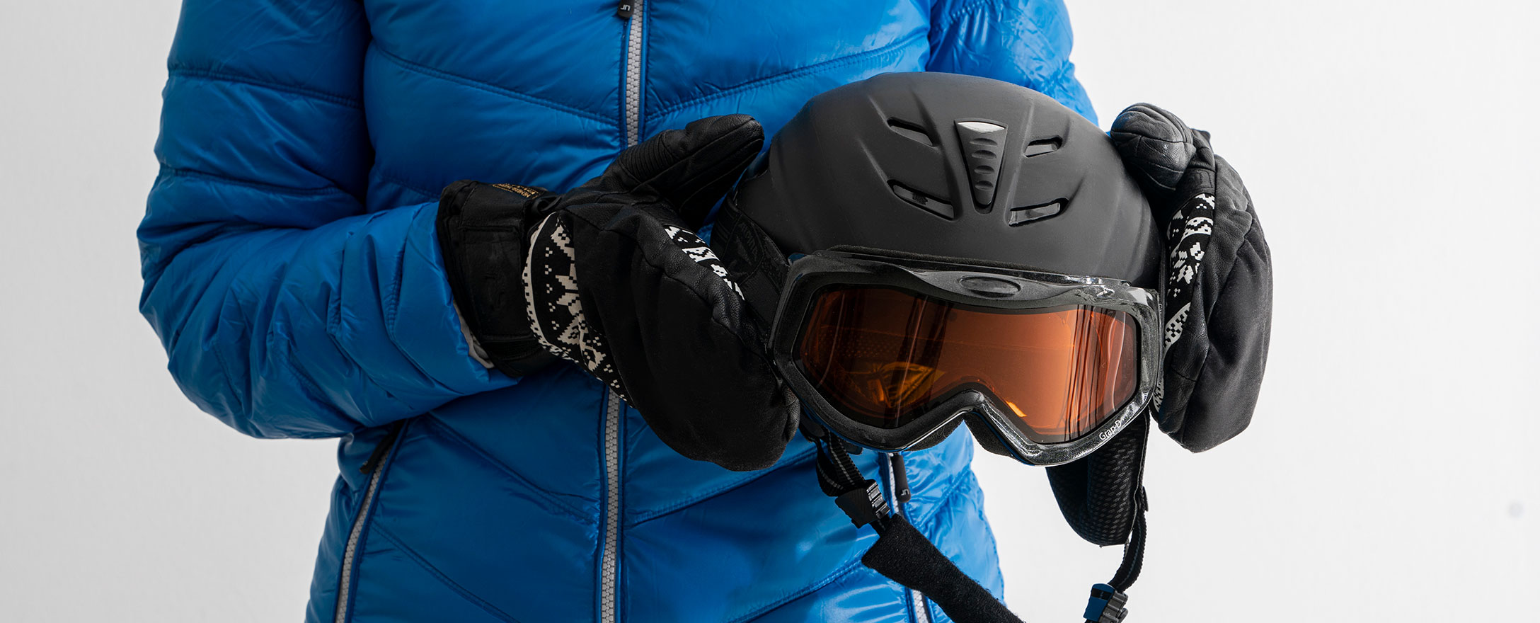 frau mit daunenjacke und skihelm