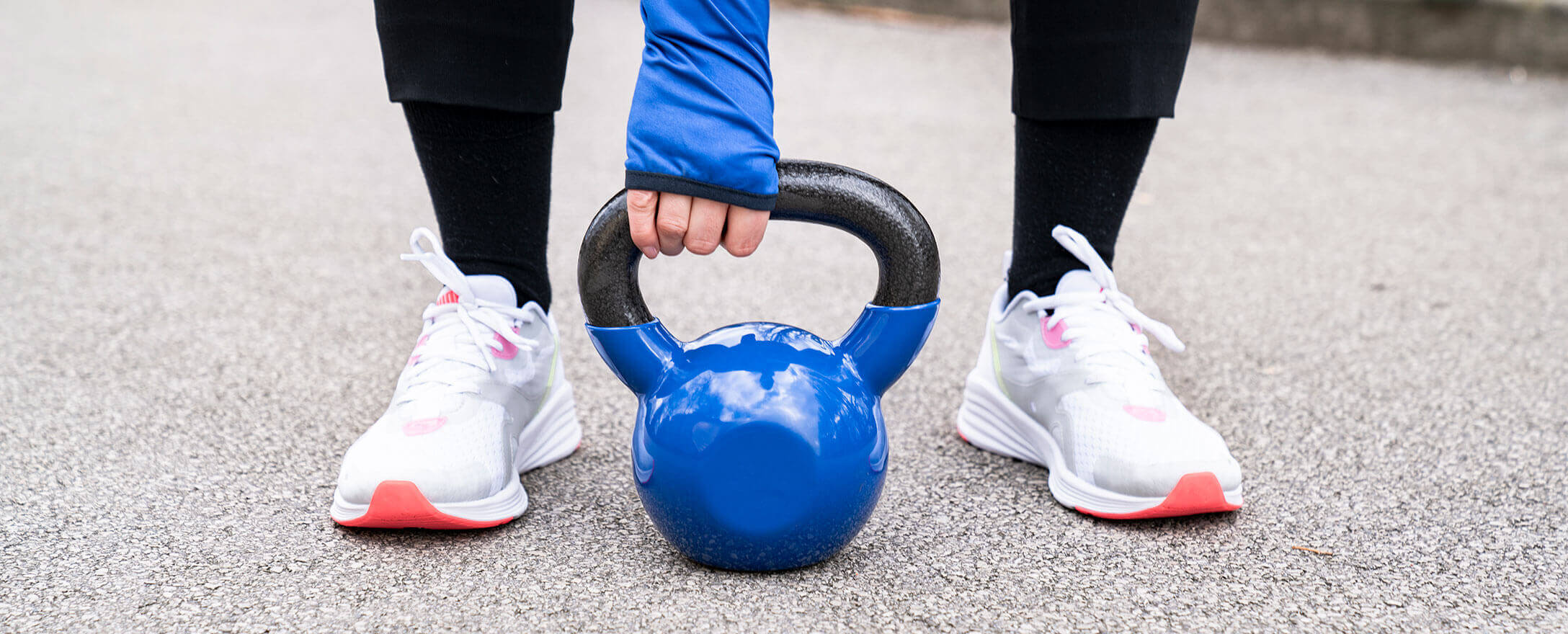 Frau bei Übung mit Kettleball im Freien