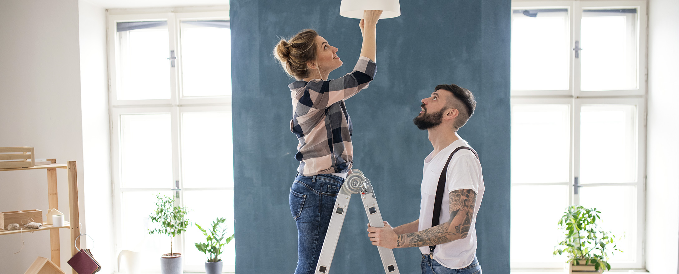Paar wechselt Glühbirne im Wohnzimmer